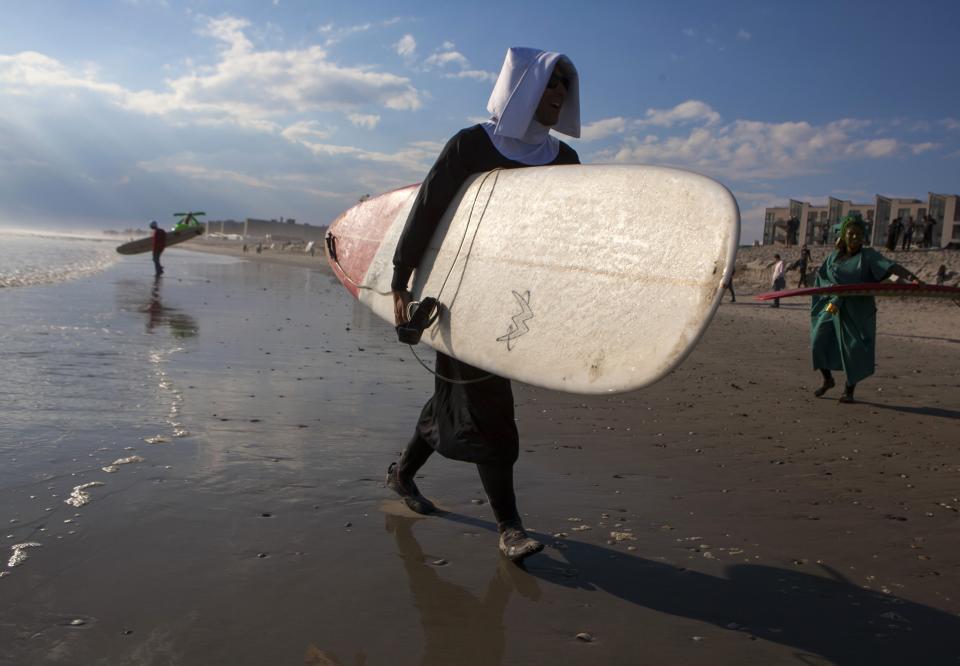 Participants walk to the water during the third annual Rockaway Halloween surf competition at Rockaway Beach in the Queens borough of New York