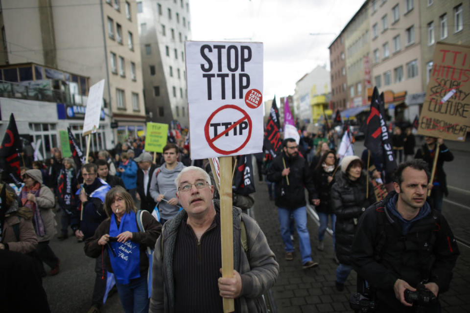 A man holds a poster with the slogan “Stop TTIP” during a protest of thousands of demonstrators against the planned Transatlantic Trade and Investment Partnership (TTIP) and the Comprehensive Economic and Trade Agreement (CETA) ahead of a visit by President Obama in Hanover, Germany, April 23, 2016. (Markus Schreiber/AP)