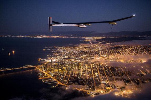 On a test flight, the Solar Impulse aircraft flies at night over San Francisco, Calif.