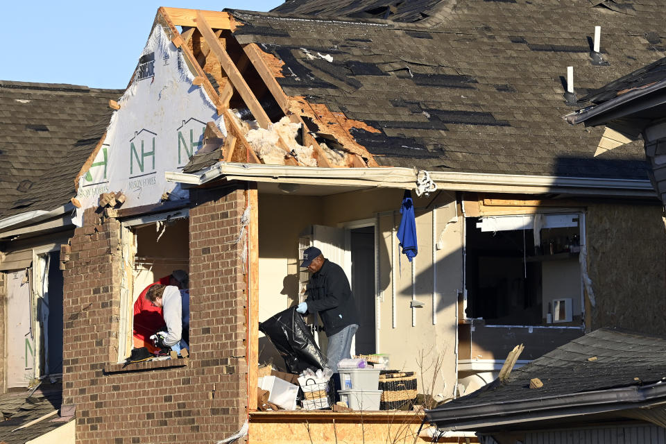 David Rogers Sr., right, sorts through belongings on the second floor of his son's damaged home in the West Creek Farms neighborhood on Sunday, Dec. 10, 2023, Clarksville, Tenn. Central Tennessee residents and emergency workers are continuing the cleanup from severe weekend storms. (AP Photo/Mark Zaleski)