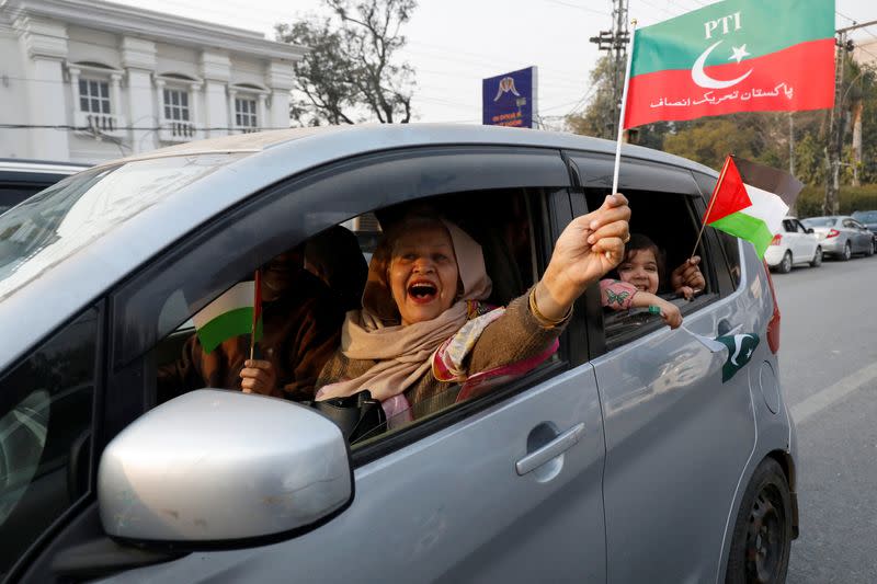 A woman supporter of former Prime Minister Imran Khan waves a flag during a rally ahead of the general elections in Lahore