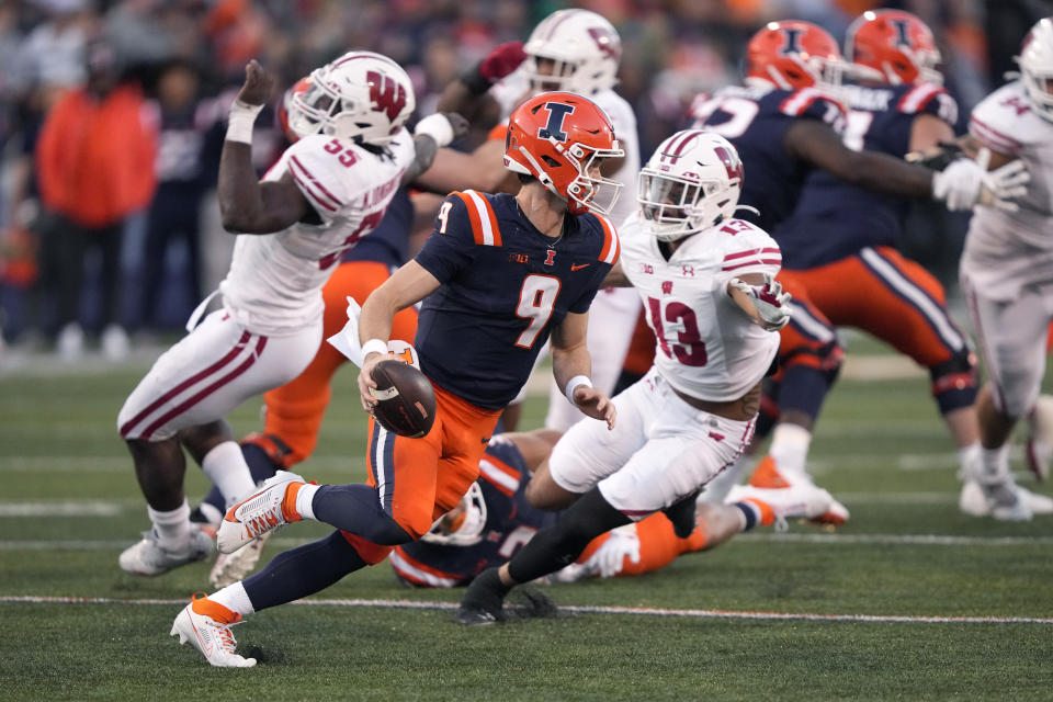 Illinois quarterback Luke Altmyer scrambles away from Wisconsin linebacker Maema Njongmeta (55) and safety Kamo'i Latud during the second half of an NCAA college football game Saturday, Oct. 21, 2023, in Champaign, Ill. (AP Photo/Charles Rex Arbogast)
