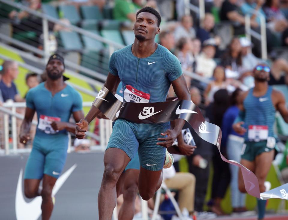 Fred Kerley, center, brings the tape with him after wiinning the men's 100 on day two of the USA Track and Field Championships 2022 at Hayward Field in Eugene Friday June 24, 2022.