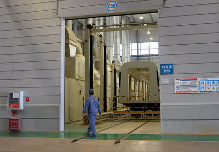 A CRRC worker walks past an unfinished metro train car in the company's Kunming factory, Yunnan province, April 11, 2016. REUTERS/Brenda Goh