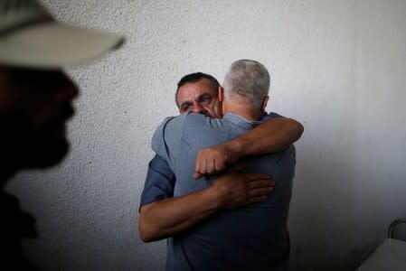 Relative of a Palestinian gunman who was killed by Israeli forces as he tried with others to cross the Gaza border, is hugged at a hospital in the northern Gaza Strip
