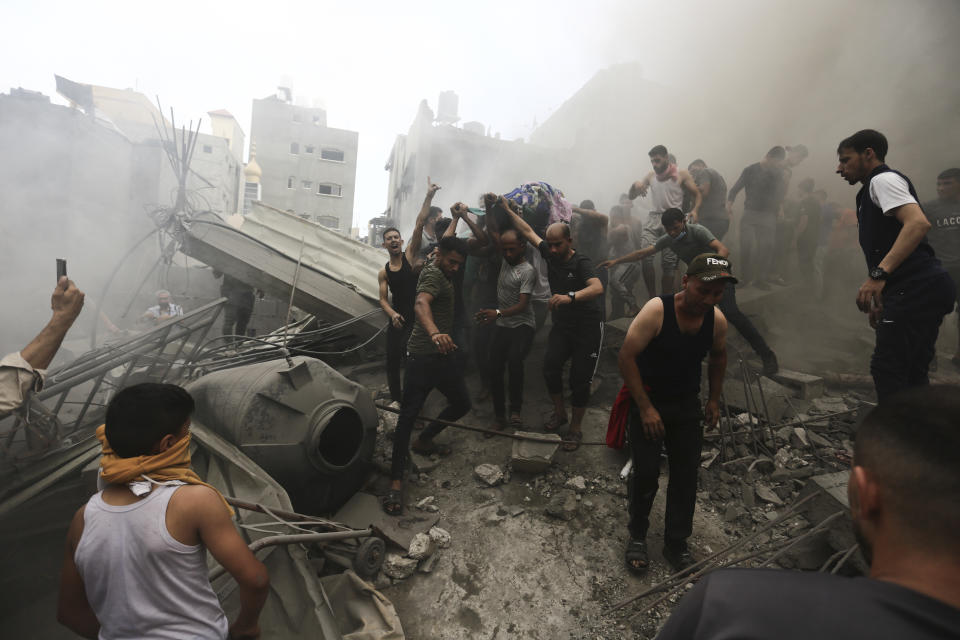 Palestinos sacan un cadáver de entre los escombros de un edificio tras un ataque israelí en el campamento de refugiados de Jebaliya, el lunes 9 de octubre de 2023, en la Franja de Gaza. (AP Foto/Ramez Mahmoud )