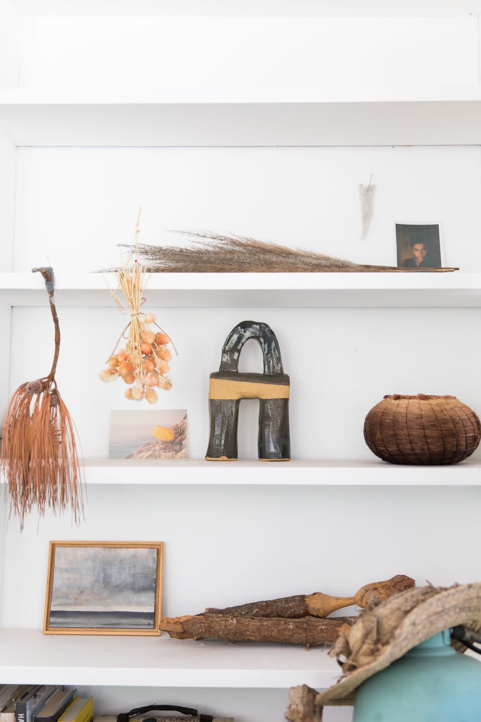 <p>"Some of my studio details... I am a collector of earthly objects with subtle tones and wild structures, I like to showcase them on the shelves around me as I work. I’m obsessed with nature’s ability to showcase organised chaos, subtle colours and shading. The painting is by John Rapp, the sculpture by <a href="https://urldefense.com/v3/__https://www.beautifulnomad.com__;!!Ivohdkk!zWCIBW6SGBfMP6Z_LK_rXjTrXML7Pm1ZrMoo8qQILMpX4GfmM9xXWUT_Nji-Cx6BC_pJ8S55-J95AQ$" rel="nofollow noopener" target="_blank" data-ylk="slk:Beautiful Nomad;elm:context_link;itc:0;sec:content-canvas" class="link ">Beautiful Nomad</a> , and the basket by <a href="https://urldefense.com/v3/__http://adcockstudios.com__;!!Ivohdkk!zWCIBW6SGBfMP6Z_LK_rXjTrXML7Pm1ZrMoo8qQILMpX4GfmM9xXWUT_Nji-Cx6BC_pJ8S6jYMiAFQ$" rel="nofollow noopener" target="_blank" data-ylk="slk:Christine Adcock;elm:context_link;itc:0;sec:content-canvas" class="link ">Christine Adcock</a>. I carved the wooden faced sculptures myself."</p>