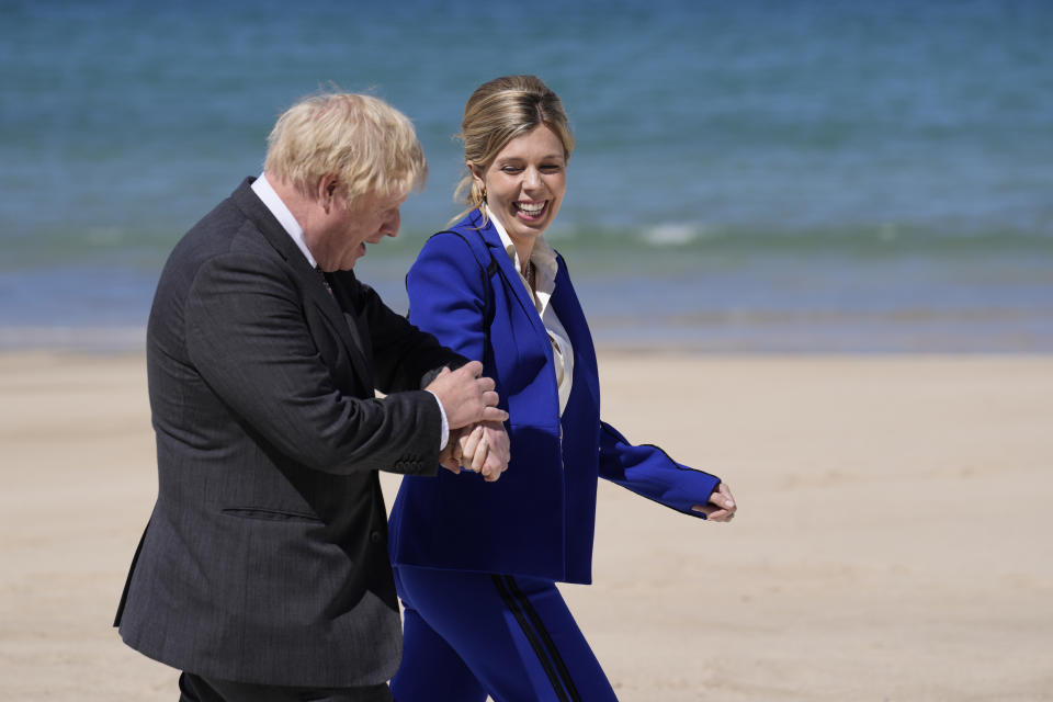 FILE - In this file photo dated Saturday, June 12, 2021, British Prime Minister Boris Johnson and his wife Carrie walk on the boardwalk as they prepare to greet guests during the G7 meeting in St. Ives, England. In a post on Instagram, Carrie Johnson has said she feels “incredibly blessed to be pregnant again”, expecting the couple’s second child. (AP Photo/Kirsty Wigglesworth, FILE)