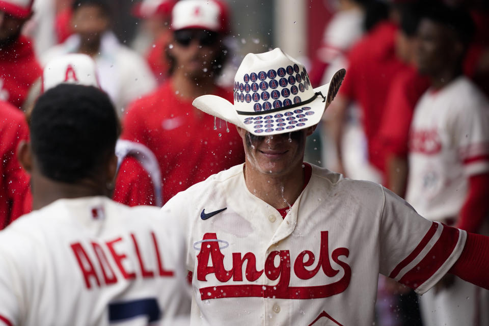 Los Angeles Angels' Jo Adell, foreground left, pours water onto Mickey Moniak while celebrating a home run by Moniak during the ninth inning of the team's baseball game against the Oakland Athletics on Thursday, Aug. 4, 2022, in Anaheim, Calif. The Athletics won 8-7. (AP Photo/Jae C. Hong)