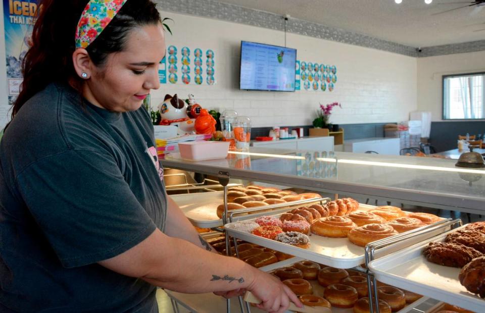 Sovanna’s Donuts employee Sarah Zeledon picks out donuts in the shop May 19, 2023.