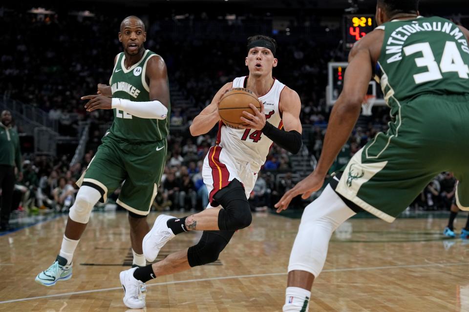 Miami Heat guard Tyler Herro (14) drives past Milwaukee Bucks forward Khris Middleton (22) during the first half of their game Monday, October 30, 2023 at Fiserv Forum in Milwaukee, Wisconsin.