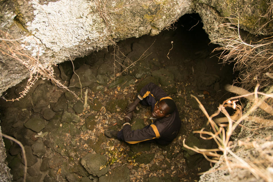Amos Kiptui, 27, sits in a cave. (Photo: Zoe Flood)
