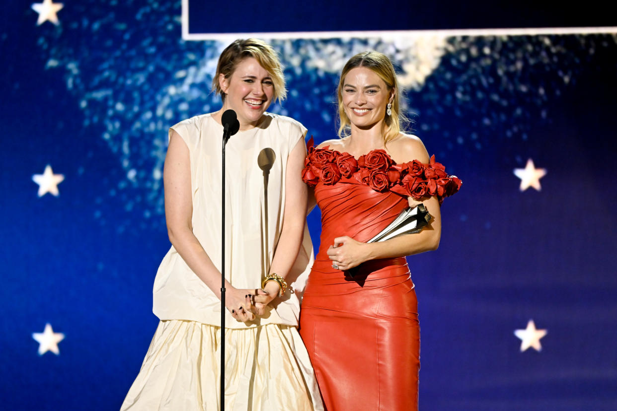Greta Gerwig, left, in white, and Margot Robbie, in red, accept the Best Comedy Award for 'Barbie' at The 29th Critics' Choice Awards held at The Barker Hangar on January 14, 2024 in Santa Monica, California. (Photo by Michael Buckner/Variety via Getty Images)