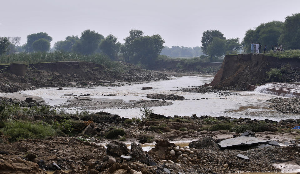 Residents examine damaged portion of a canal washed away by a powerful earthquake in Jatlan near Mirpur, in northeast Pakistan, Wednesday, Sept. 25, 2019. Thousands of people whose homes were damaged because of a strong earthquake are desperately waiting for the arrival of government help, 22 hours after the 5.8 magnitude tremor struck Pakistan-held Kashmir and elsewhere, killing 25 people and injuring 700. (AP Photo/Anjum Naveed)