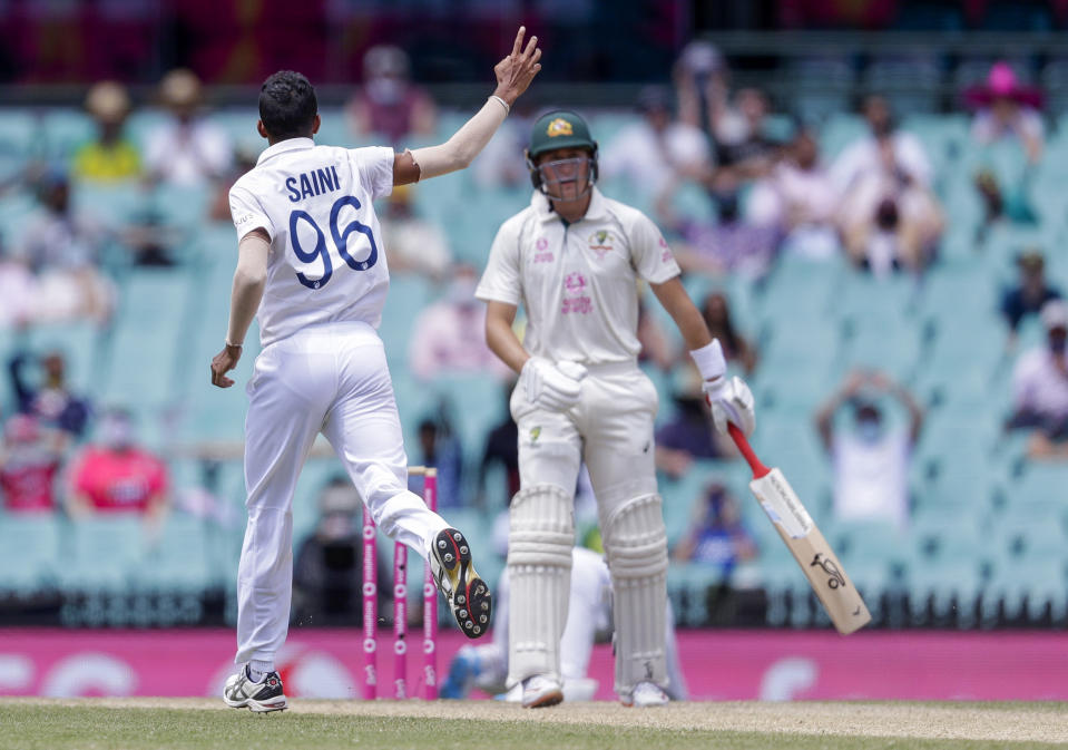 India's Navdeep Saini, left, celebrates the dismissal of Australia's Marnus Labuschagne, right, during play on day four of the third cricket test between India and Australia at the Sydney Cricket Ground, Sydney, Australia, Sunday, Jan. 10, 2021. (AP Photo/Rick Rycroft)