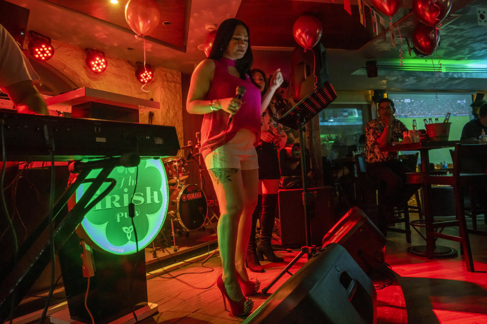 Una mujer canta en el "The Irish Pub," uno de los bares que pasarán los partidos del Mundial 2022 en pantallas en vivo en Doha, Qatar, el jueves 20 de octubre de 2022. (AP Foto/Nariman El-Mofty)