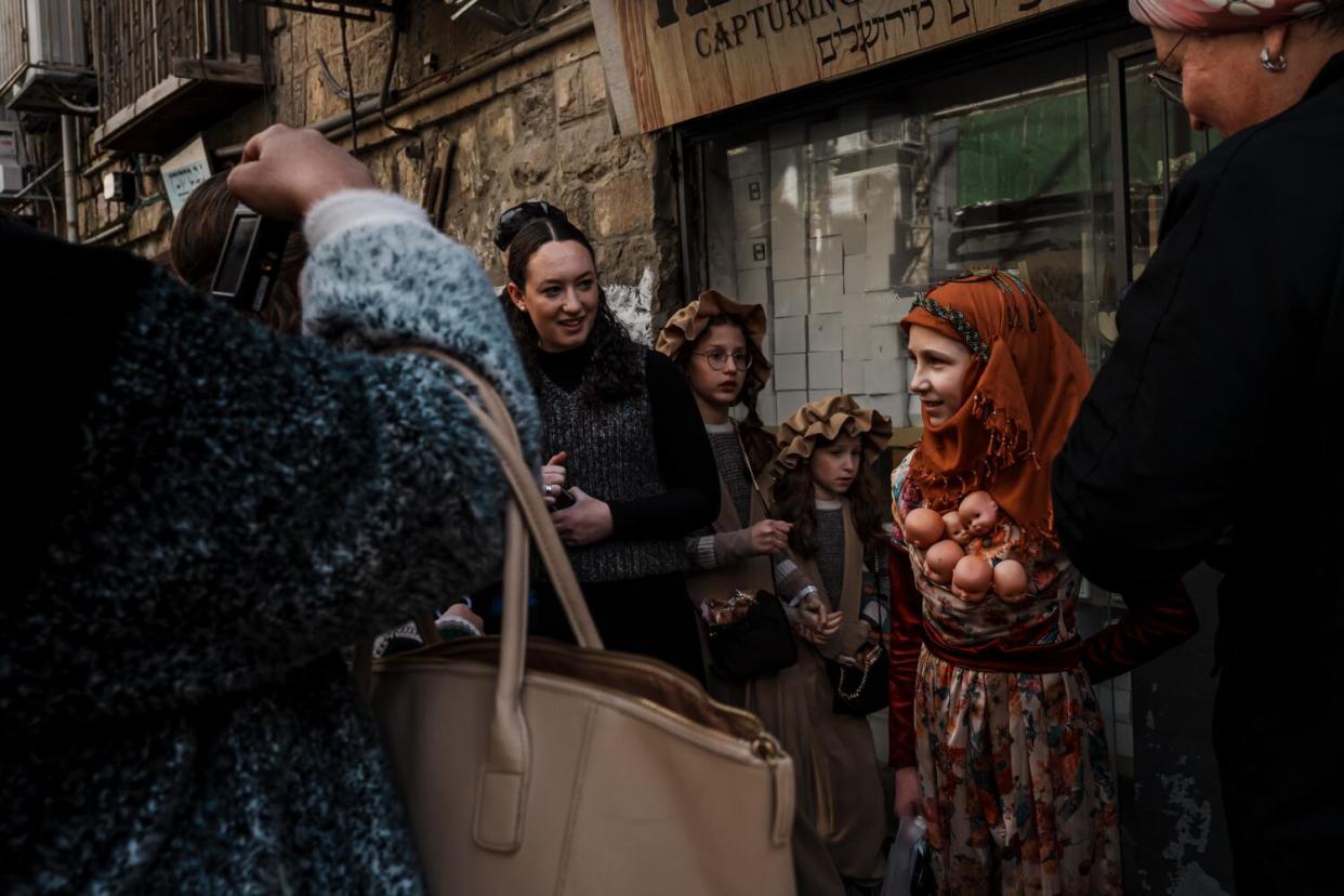 A young girl attending Purim celebrations in Jerusalem wears a costume meant to symbolize motherhood.