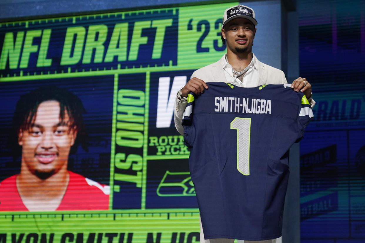 Ohio State wide receiver Jaxon Smith-Njigba holds a jersey after being chosen by the Seattle Seahawks with the 20th pick in the NFL Draft on Thursday, April 27, 2023, in Kansas City, Mo. (AP Photo/Jeff Roberson)