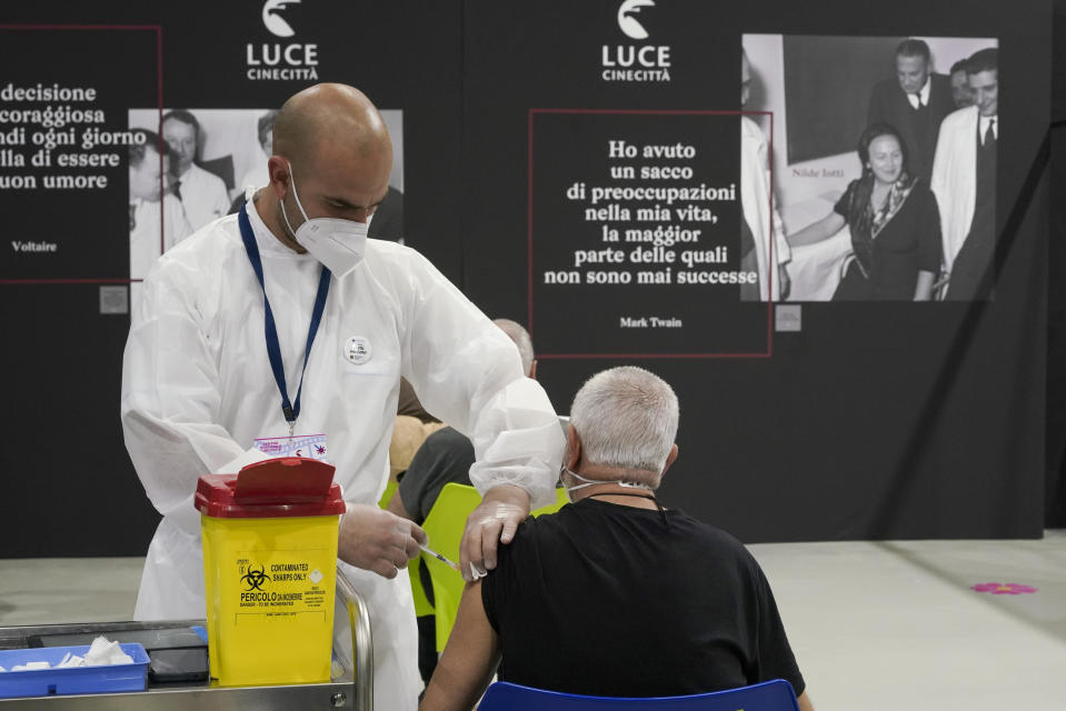 FILE - A man receives a dose of the Pfizer COVID-19 vaccine, at a vaccination center set at Rome's Cinecitta' film studios, on April 20, 2021. Italy is making life more uncomfortable for non-vaccinated people as the holidays near, excluding them from indoor restaurant dining, theaters and museums into the New Year in a bid to control the spread of coronavirus and encourage vaccine skeptics to get the shot. Starting Monday, Dec. 6, 2021 through Jan. 15, police can control whether diners seated in restaurants or bars have a "super" health pass certifying that they are either vaccinated or have recovered from the virus.(AP Photo/Andrew Medichini, File)