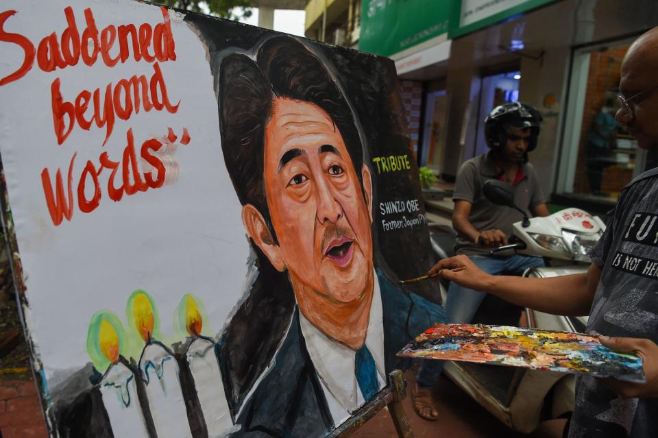 An artists gives final tocuhes to a painting of former Japanese prime minister Shinzo Abe, in Mumbai on July 8, 2022, to pay tribute following his death after he was shot at a campaign event in the Japanese city of Nara. (Photo by Punit PARANJPE / AFP) (Photo by PUNIT PARANJPE/AFP via Getty Images) ORIG FILE ID: AFP_32E32GC.jpg