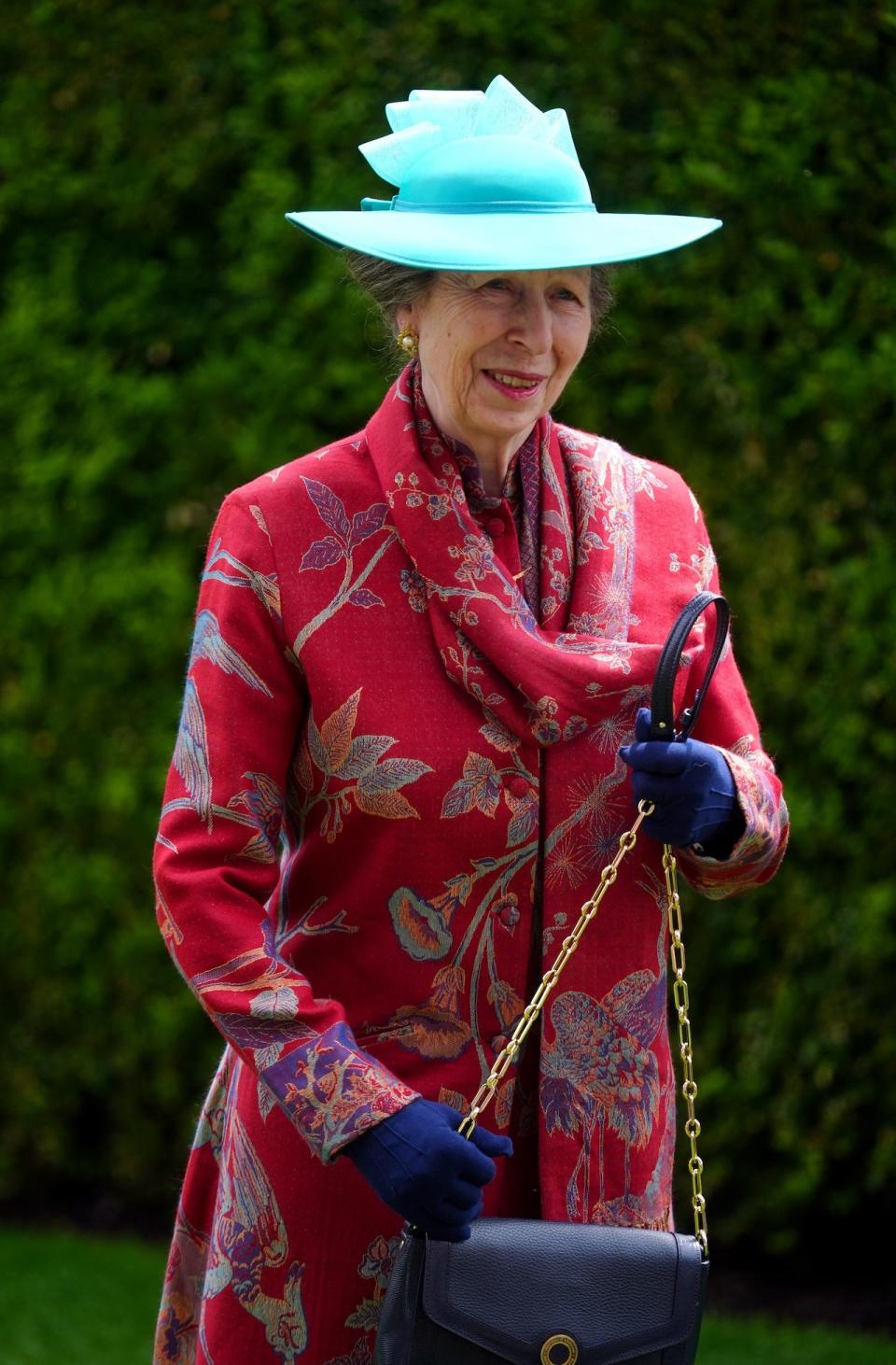 Princess Anne wearing an electric blue hat and a red coatdress.