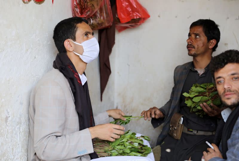 Customer wearing a protective face mask buys qat, a mild stimulant, at a qat market amid concerns of the spread of the coronavirus disease (COVID-19) in Sanaa