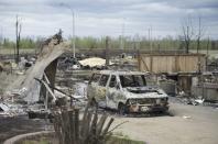 A van burned by a wildfire stands in the Beacon Hill neighborhood during a media tour of the fire-damaged city of Fort McMurray, Alberta, on Monday, May 9, 2016. (Jonathan Hayward/The Canadian Press via AP)