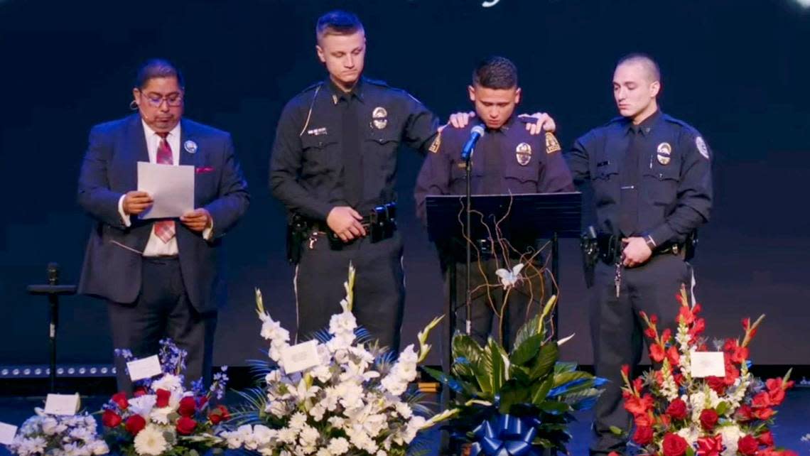 Independence police officer Nicolas Pablo, at podium, is supported by fellow police officers while he shares his memories of North Kansas City police officer Daniel Vasquez during Vasquez’s funeral ceremony Wednesday, July 27, 2022, at Vineyard Church in Kansas City. Pablo was friends and in the same police academy class with Vasquez who was killed while on duty last week in North Kansas City. Independence police officer Blaize Madrid-Evans who was killed while on duty last September was in the same police academy class with Vasquez and Pablo.