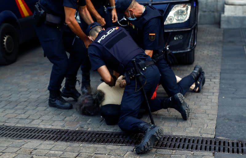 A person is detained by police officers during a protest against Spain's monarchy for the first time since former Spanish King Juan Carlos left the country amid an investigation into his involvement in a high-speed rail contract in Saudi Arabia, in Madrid