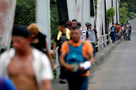 Honduran migrants, part of a caravan trying to reach the U.S., walk during a new leg of their travel in Escuintla, Guatemala October 18, 2018. REUTERS/Edgard Garrido