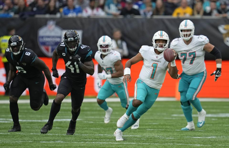 Miami Dolphins quarterback Tua Tagovailoa (1) runs with the ball during the second half of an NFL football game between the Miami Dolphins and the Jacksonville Jaguars at the Tottenham Hotspur stadium in London, England, Sunday, Oct. 17, 2021. (AP Photo/Matt Dunhan)