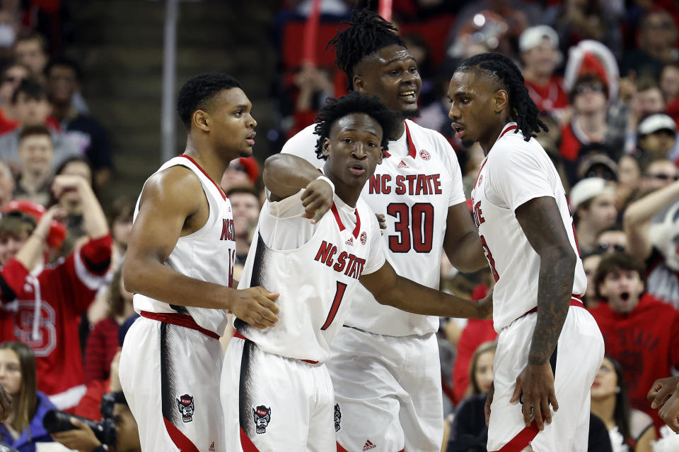 North Carolina State's Jarkel Joiner (1) talks with teammates, from left, Casey Morsell, D.J. Burns Jr. (30) and Greg Gantt, right, during the second half of an NCAA college basketball game against the Miami in Raleigh, N.C., Saturday, Jan. 14, 2023. (AP Photo/Karl B DeBlaker)