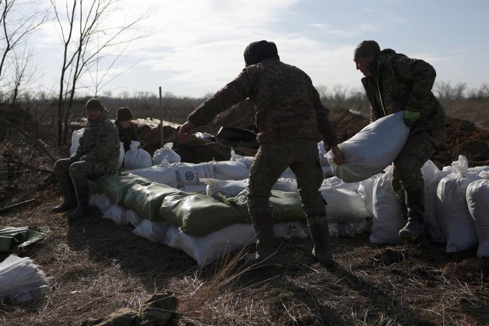 Ukrainian soldiers pile up earthbags to build a fortification near Avdiivka on Saturday (AFP via Getty Images)