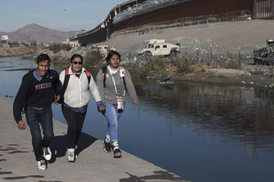 Migrants return to the Ciudad Juarez, Mexico side of the border as U.S. military stand guard in El Paso, Texas, right, Tuesday, Dec. 20, 2022. The Supreme Court issued a temporary order to keep pandemic-era limits on asylum-seekers in place, though it could be brief, as conservative-leaning states push to maintain a measure that allows officials to expel many but not all asylum-seekers. (AP Photo/Christian Chavez)