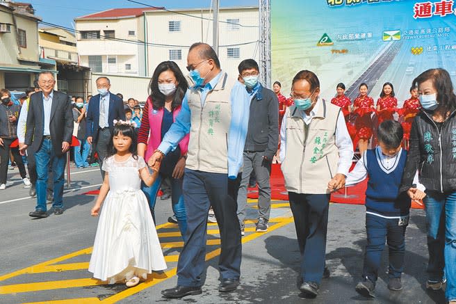 台20線北側增設國道兩側平面道路工程耗時3年終於完工，24日由台南市副市長許育典（前左二）牽著小女孩走向新開闢的路，宣告通車啟用。（曹婷婷攝）