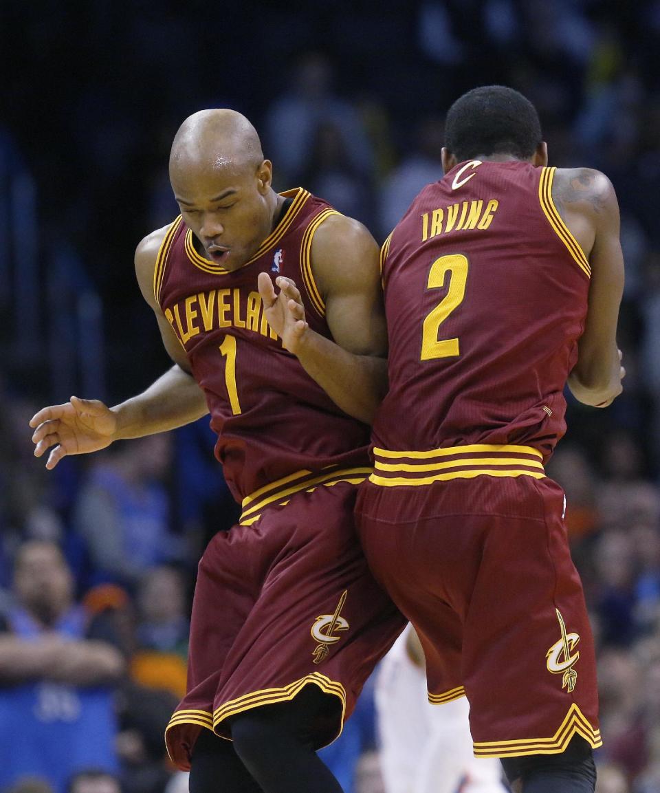 Cleveland Cavaliers guard Jarrett Jack (1) and guard Kyrie Irving (2) celebrate in the fourth quarter of an NBA basketball game against the Oklahoma City Thunder in Oklahoma City, Wednesday, Feb. 26, 2014. Cleveland won 114-104. (AP Photo/Sue Ogrocki)