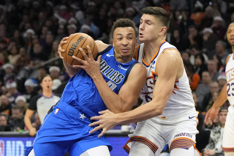 Dallas Mavericks guard Dante Exum (0) drives on Phoenix Suns guard Grayson Allen during the first half of an NBA basketball game, Monday, Dec. 25, 2023, in Phoenix. (AP Photo/Rick Scuteri)