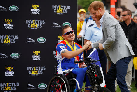 Britain's Prince Harry shakes hands with a participant of the Invictus Games at the Royal Botanic Garden in Sydney, Australia October 21, 2018. REUTERS/Phil Noble