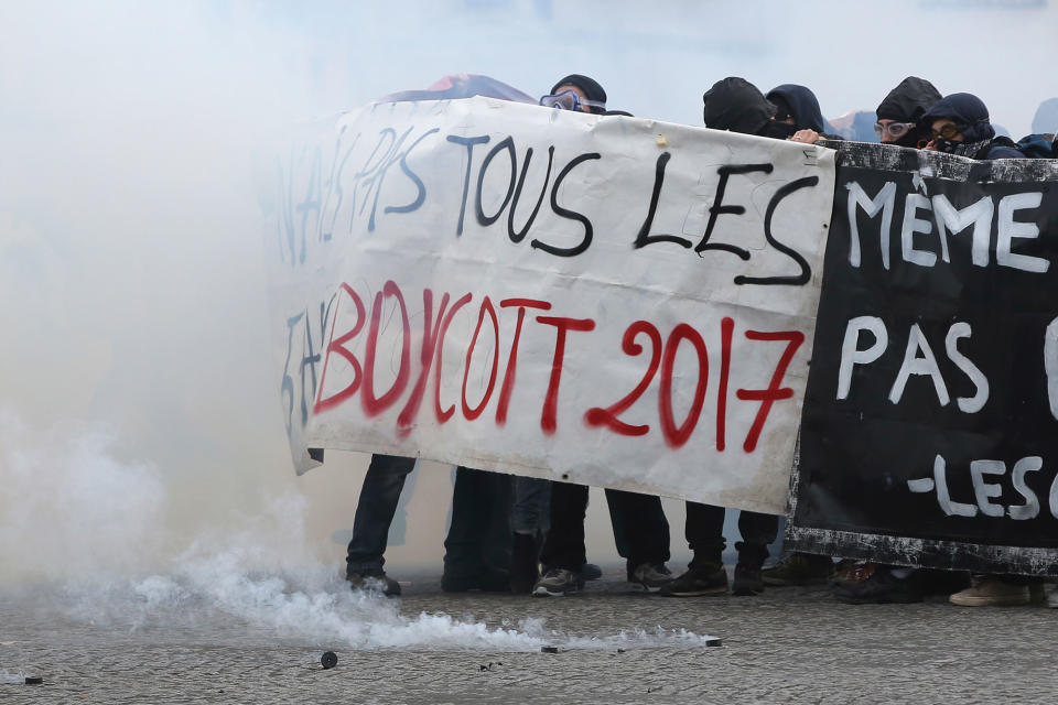 <p>Youths shield behind a banner as Paris police are firing tear gas, during the May Day demonstration, Monday May 1, 2017, in Paris. Scores of hooded youth have thrown Molotov cocktails at security forces who fired back with tear gas during the May Day workers’ march in Paris. (AP Photo/Thibault Camus) </p>