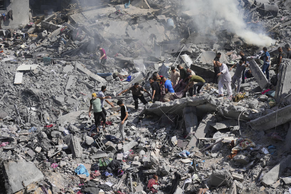 Palestinians pull dead from the building destroyed in an Israeli airstrike in Bureij refugee camp Gaza Strip, Wednesday, Oct. 18, 2023. (AP Photo/Hatem Moussa)