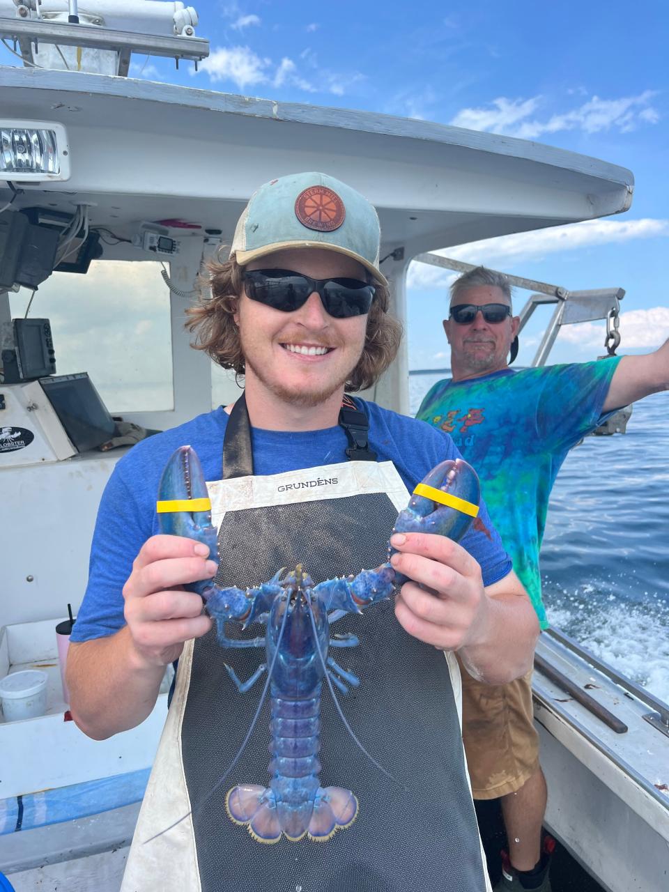 Stratham lobsterman Joseph Kramer caught a rare cotton candy lobster off of New Castle on Sunday, July 21, 2024, estimated to be a one-in-100 million find, according to the Seacoast Science Center. Here, he is seen holding the cotton candy lobster with his father Dave Kramer in the background on Sunday, July 21, 2024.