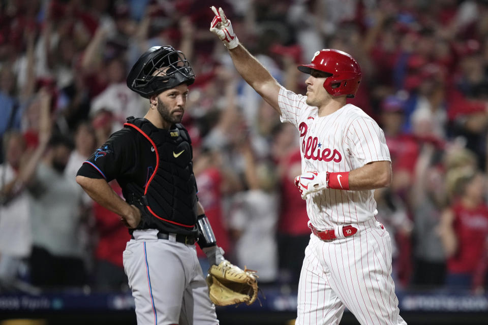 Philadelphia Phillies' J.T. Realmuto, right, reacts past Miami Marlins catcher Jacob Stallings after hitting a home run during the fourth inning of Game 2 in an NL wild-card baseball playoff series, Wednesday, Oct. 4, 2023, in Philadelphia. (AP Photo/Matt Slocum)