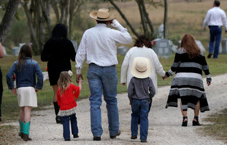 A mourner arrives with his children for the burial of Richard and Therese Rodriguez after the husband and wife were killed in the shooting at First Baptist Church of Sutherland Springs in Texas, U.S., November 11, 2017. REUTERS/Rick Wilking