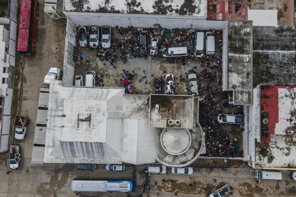 Migrants crowd into the patio at the Attorney Generals office after they were detained from inside cargo trailers driving on the highway, in Coatzacoalcos, Veracruz state, Mexico, Friday, Nov. 19, 2021. About 500 migrants were riding in two cargo trucks when they were stopped and detained by the Criminal Investigation Agency and the National Immigration Institute, according to those two institutes. (AP Photo/Felix Marquez)