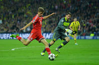 Thomas Mueller of Bayern Muenchen (L) attempts a shot past Roman Weidenfeller of Borussia Dortmund during the UEFA Champions League final.