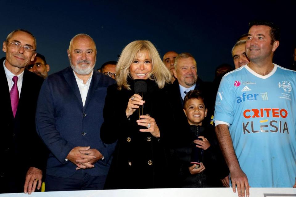 Brigitte Macron, President of the Paris Hospitals Foundation, receives a cheque for 50,000 euros at the end of the charity football match between the Varietes club de France and the carers of the Poissy Saint Germain hospital at the Leo Lagrange stadium in Poissy, France, Oct. 14. - Credit: AP