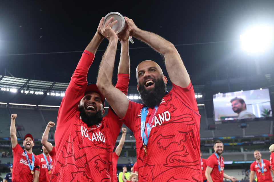 Pictured left to right, England stars Adil Rashid and Moeen Ali celebrate with the trophy after winning the T20 World Cup final against Pakistan.