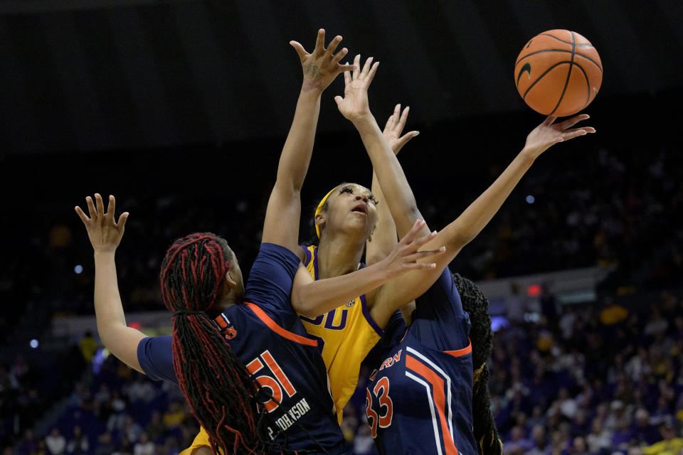 FILE - LSU guard Angel Reese, shoots between a double team of Auburn center Precious Johnson (51) and forward Kharyssa Richardson (33) in the second half of an NCAA college basketball game Sunday, Jan. 15, 2023, in Baton Rouge, La. Reese was honored as an All-American by The Associated Press on Wednesday, March 15, 2023. (AP Photo/Matthew Hinton, File)