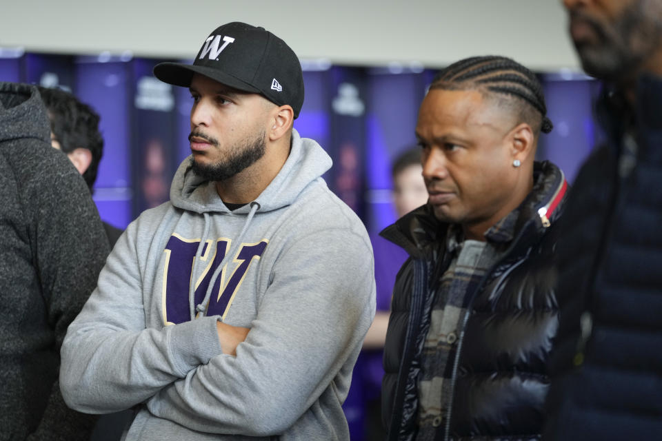 Former NFL and Washington football players Jermaine Kearse, left, and Mario Bailey, right, listen as Washington head coach Jedd Fisch speaks during an NCAA college football press conference Tuesday, Jan. 16, 2024, in Seattle. (AP Photo/Lindsey Wasson)