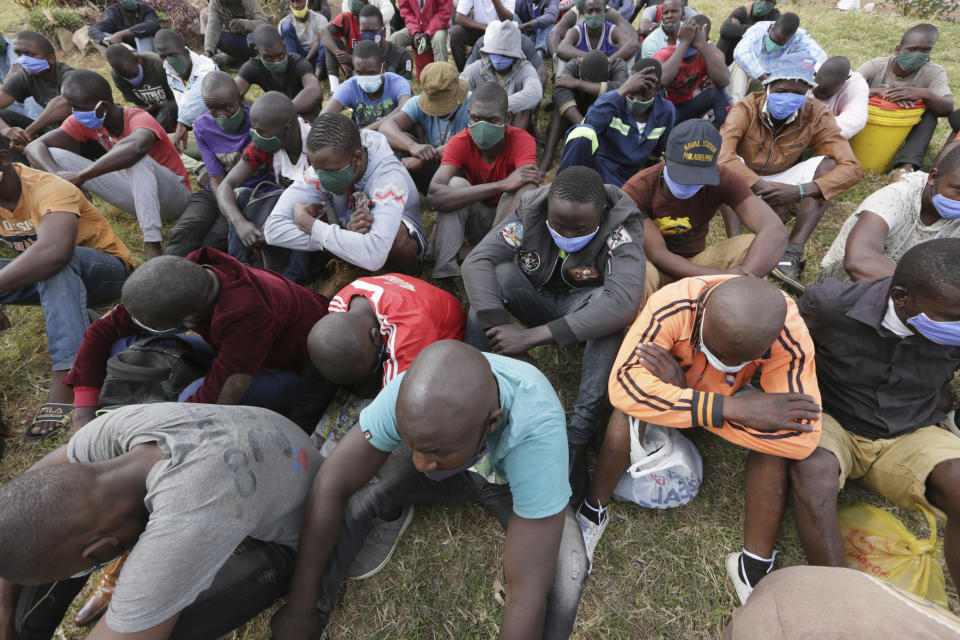 Prisoners wait for transport following their release from Chikurubi prison on the outskirts of Harare, Saturday, April 17, 2021. Zimbabwe began the release of about 3,000 prisoners under a presidential amnesty aimed at easing congestion and minimizing the threat of COVID-19 across the country's overcrowded jails. (AP Photo/Tsvangirayi Mukwazhi)